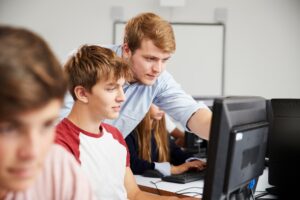 Jugendliche zur Ausbildung zum Kaufmann für IT-System Management vor einem PC